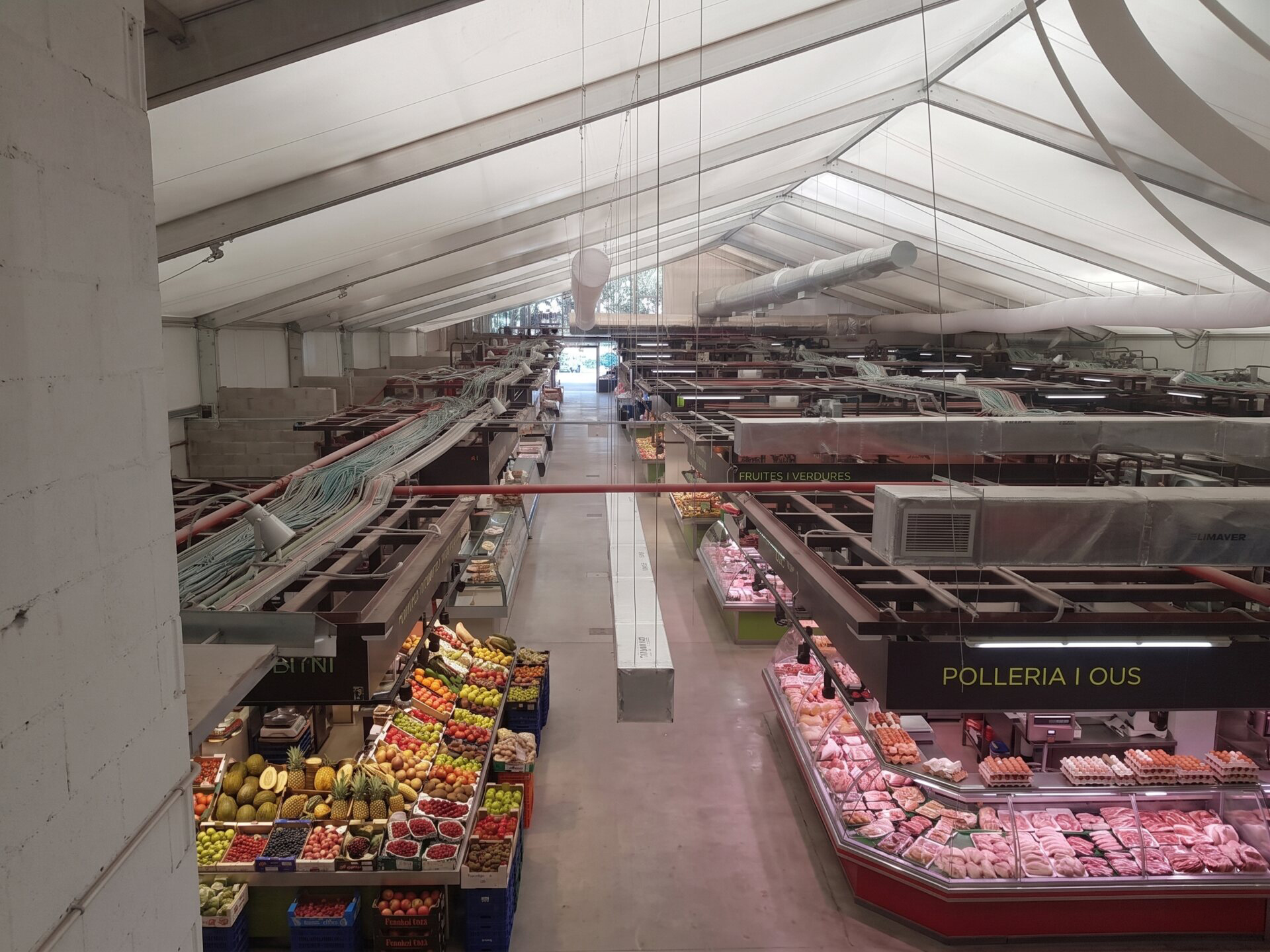 Intérieur d'un marché municipal avec des étals de nourriture dans un bâtiment préfabriqué